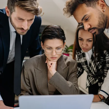 Dott. Cristiano Pedersini - Colleghi vicini e concentrati davanti allo schermo, simbolo di supporto reciproco, condivisione e ricerca di senso nel lavoro, supporto per il burnout lavorativo
